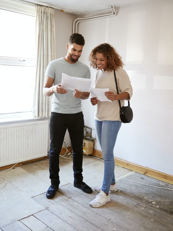 couple-buying-house-for-first-time-looking-at-house-survey-in-room-to-be-renovated-1.jpg